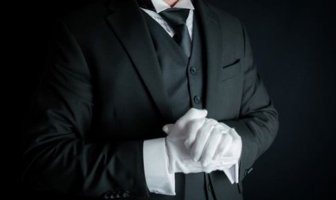 手を組むスーツの男性